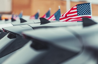 Véhicules électriques devant des drapeaux américains, représentant le marché américain des VE.